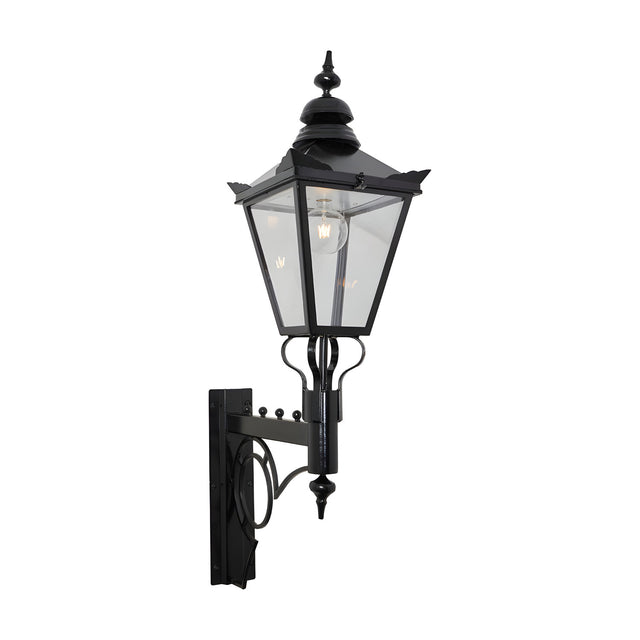 Large Victorian wall lantern in black, tapered four-sided glass head with stepped crown and finial, mounted on a scroll bracket, E27 bulb visible, plain white background.