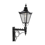 Large Victorian wall lantern in black with tapered four-sided glass head, stepped crown, cast finial, and scroll bracket, shown on a plain white background.