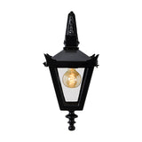 Victorian downturned wall lantern in black cast iron with a tapered four-sided glass head, stepped crown, corner tips and cast finial, shown lit on a plain white background.