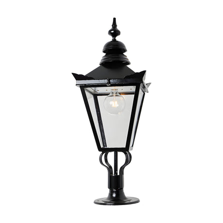 Large Victorian cast iron pillar light in black with a tapered four-sided glass panel head, stepped crown, and cast finial, mounted on a pier base against a plain white background.