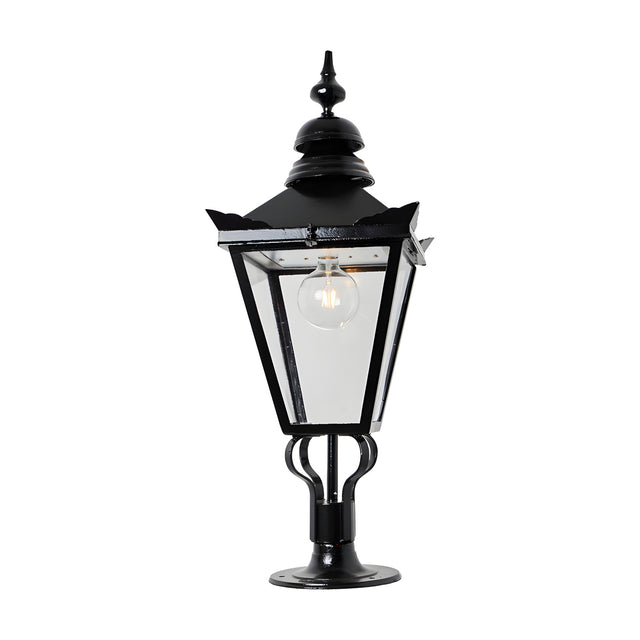 Large Victorian cast iron pillar light in black with a tapered four-sided glass panel head, stepped crown, and cast finial, mounted on a pier base against a plain white background.