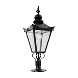 Large Victorian pillar light in black cast iron with a tapered four-sided glass head, stepped crown, corner tips, ornate finial, and pier cap base, shown on a plain white background.