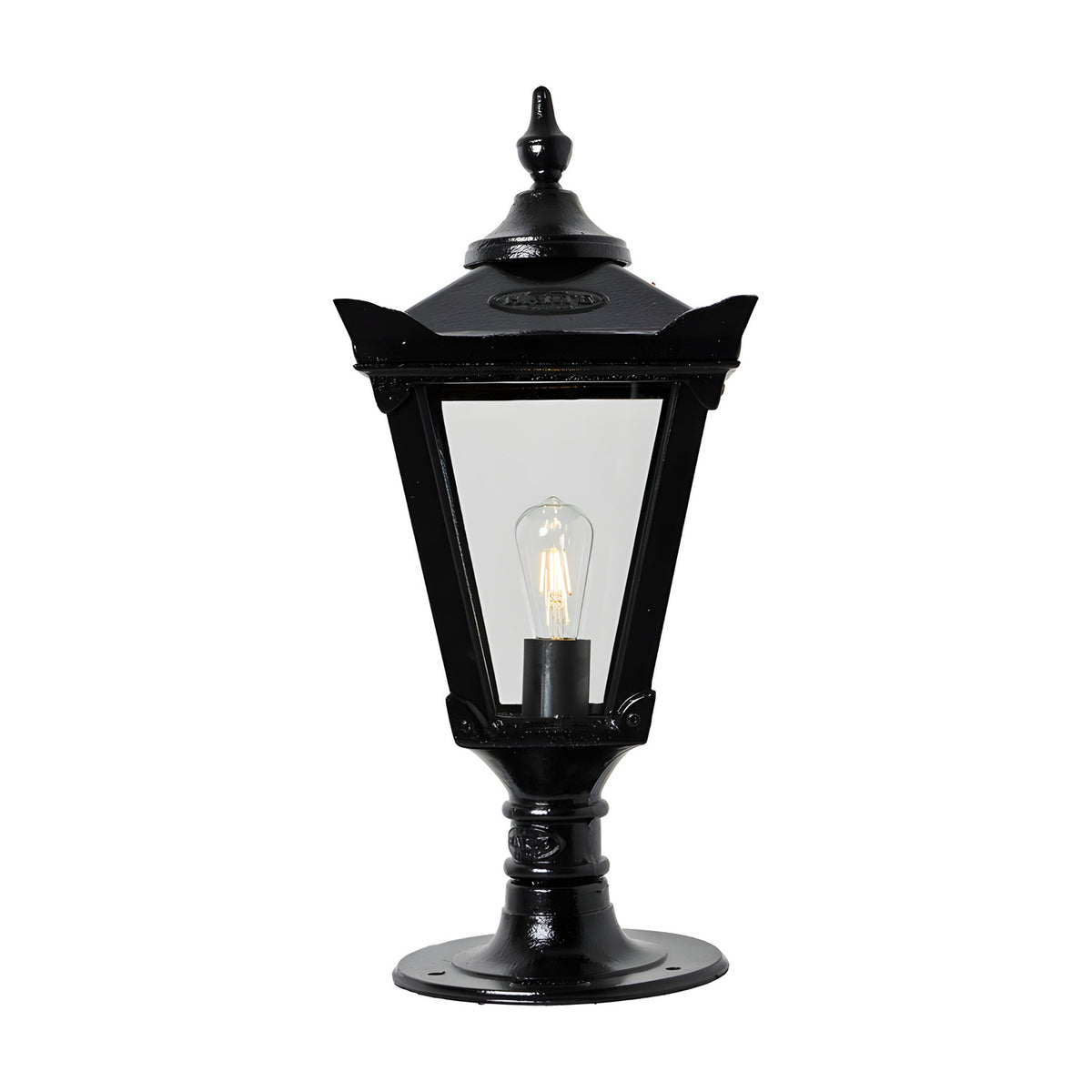 Medium Victorian Cast Iron Pillar Light in black with a tapered four-sided glass lantern, stepped crown, corner tips and cast finial, shown lit on a pedestal base against a white background.