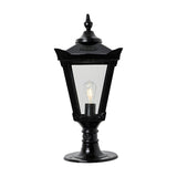 Medium Victorian Cast Iron Pillar Light in black with a tapered four-sided glass lantern, stepped crown, corner tips and cast finial, shown lit on a pedestal base against a white background.