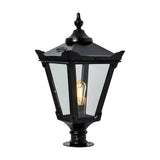 Large Victorian cast iron pillar light in black with a tapered four-sided glass head, stepped crown, corner tips, cast finial and pier-mount base, shown lit on a plain white background.