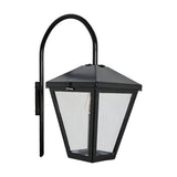 Contemporary downturned wall lantern in black, tapered glass-panelled lantern head with peaked roof and curved mounting arm, shown on a plain white background.