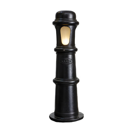 Large Victorian cast iron bollard light in black, a stepped beaded column with a frosted polycarbonate lens window illuminated, on a plain white background.