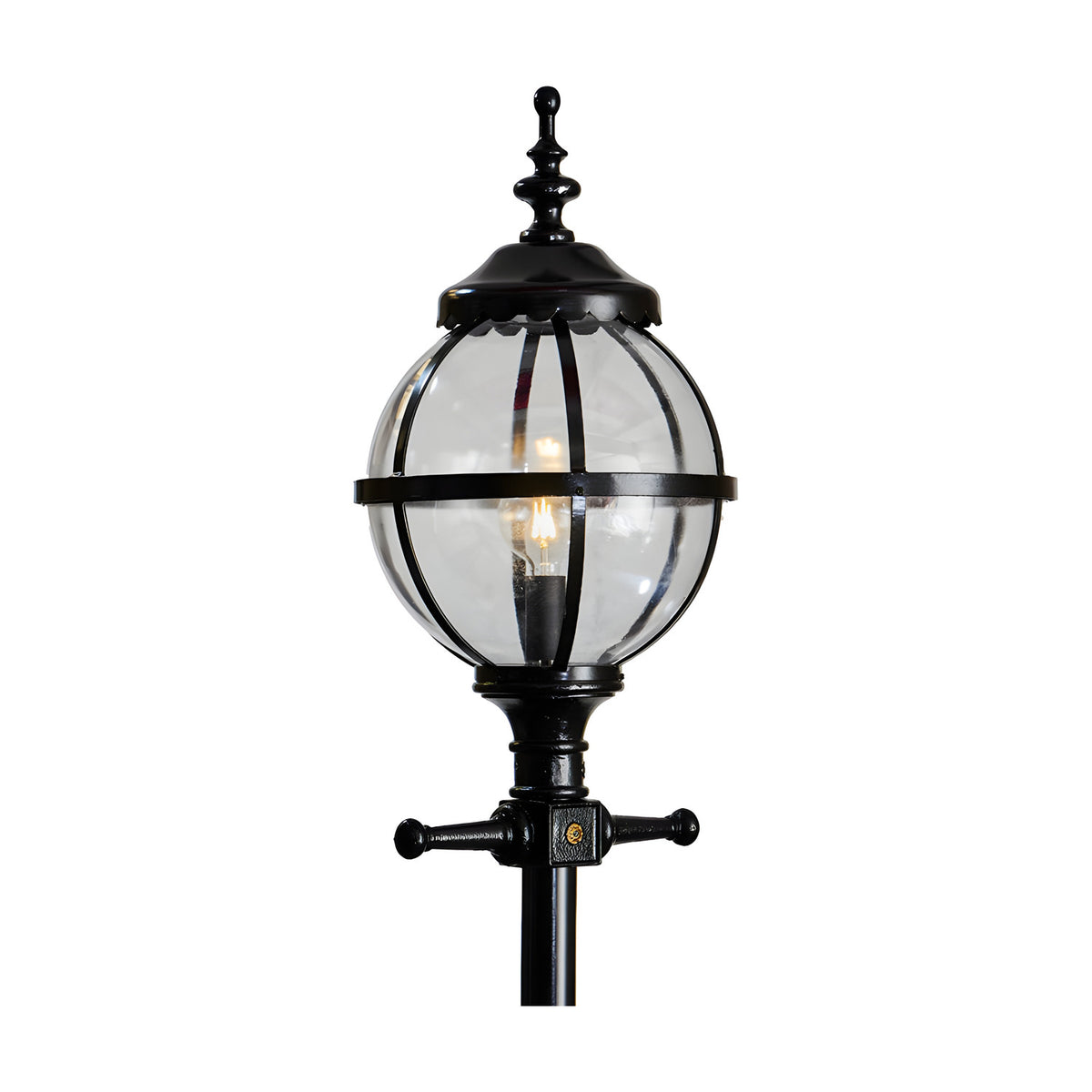 Victorian Cast Iron Globe Lamp Post in black, showing a clear glass globe shade in a banded cage cap on a decorative post, lit bulb visible, plain white background.
