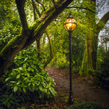 Victorian Cast Iron Globe Lamp Post 2.7m in black, single globe head in banded cage with lit E27 bulb, tall traditional post set on a garden path amid trees.