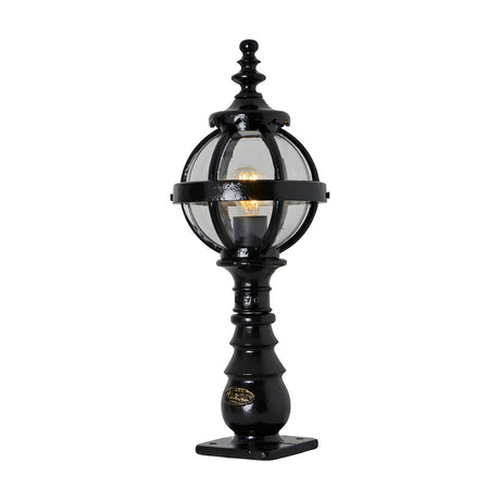 Small Victorian cast iron globe pedestal post light in black, single-light fixture with clear glass globe in a banded cage on a decorative base, shown on a plain white background.