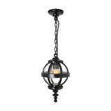Small Victorian globe hanging lantern in black, cast iron banded cage with clear glass panels, suspended on a black chain from a ceiling mount, plain white background.