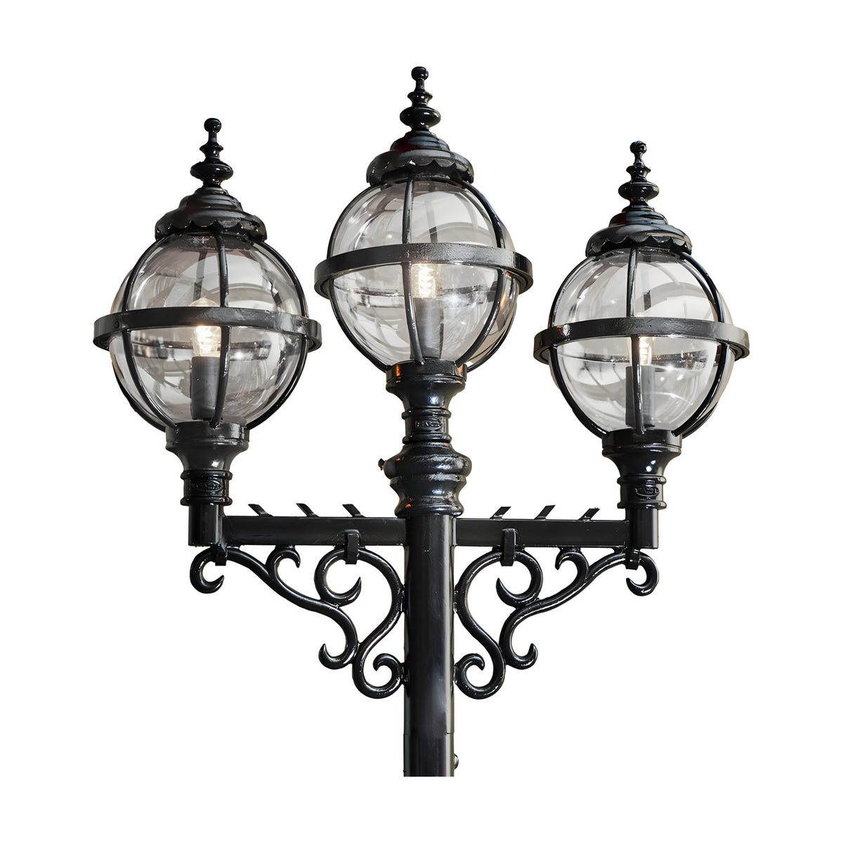 Victorian-style triple-headed lamp post in black cast iron, featuring three globe lanterns in banded cages with ornate finials and scrolled brackets, shown against a plain white background.