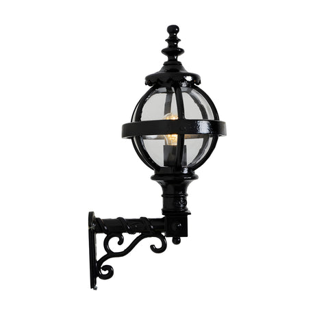 Small Victorian Globe Wall Lantern in black, cast iron banded cage globe with clear glass and lit bulb, mounted on a scroll bracket, shown on a white background.