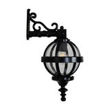 Small Victorian cast iron downturned globe wall lantern in black, with banded cage design and clear glazing, on an ornate scroll wall bracket against a plain white background.