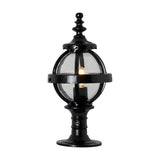 Small Victorian Globe Pillar Light in black, cast iron banded cage with clear glass globe on a decorative pedestal base, lit bulb visible, plain white background.
