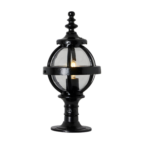 Small Victorian Globe Pillar Light in black, cast iron banded cage with clear glass globe on a decorative pedestal base, lit bulb visible, plain white background.