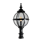 Victorian Manor cast iron globe pedestal post light in black, with a banded cage globe shade, ornate cap and finial, and a decorative column base, shown lit against a plain white background.