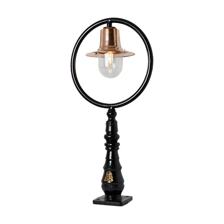 Large railway-style cast iron pedestal post light with a black circular hoop frame, copper spun shade, and clear glass dome, on a black turned column base, shown on a white background.