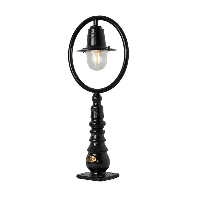 Small black cast iron Railway Style pedestal post light with a hoop frame, spun shade, clear glass dome, and column base with square mounting plate.