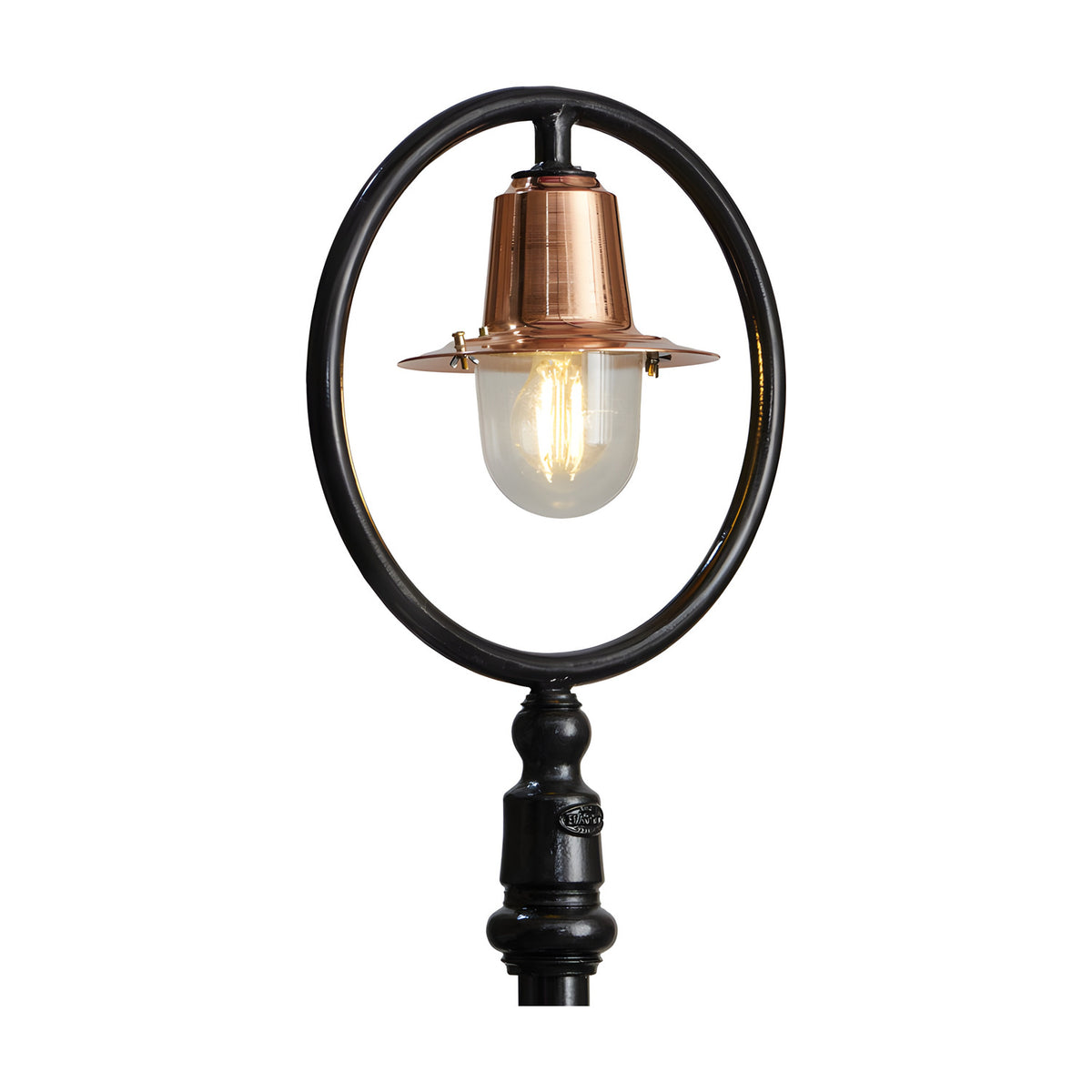 Cast iron lamp post from the Station Master range, with a copper spun shade and clear glass dome set within an oval hoop arm, on a black traditional base, plain white background.