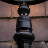 Close-up of the Railway Style Cast Iron Lamp Post 2.73m in black, showing the ornate cast column with embossed Harte maker's plate below the glass dome.