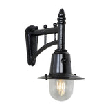 Small railway style wall lantern in black, with a trussed cast arm, spun metal shade and clear glass dome housing an exposed filament bulb, shown on a plain white background.
