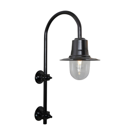 Large vintage wall lantern in black on a goose neck bracket, with a teardrop metal shade over a clear glass dome and lit bulb, shown on a plain white background.