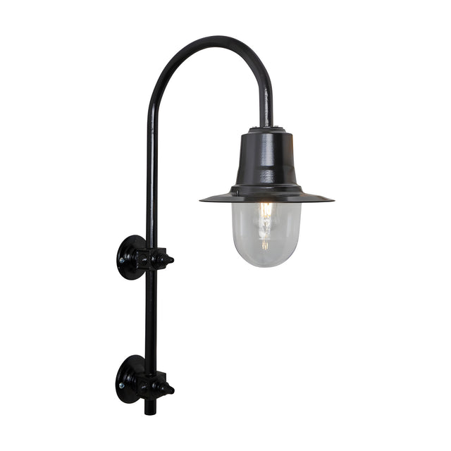 Large vintage wall lantern in black on a goose neck bracket, with a teardrop metal shade over a clear glass dome and lit bulb, shown on a plain white background.