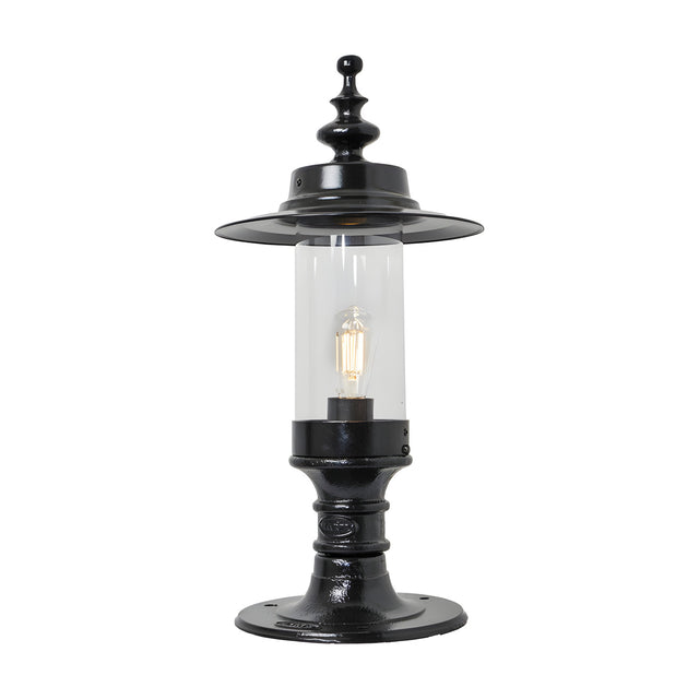 Large Georgian cast iron pillar light in black with a shallow crown-shaped hood, clear cylindrical glass shade, and flat pier cap base, shown on a white background.