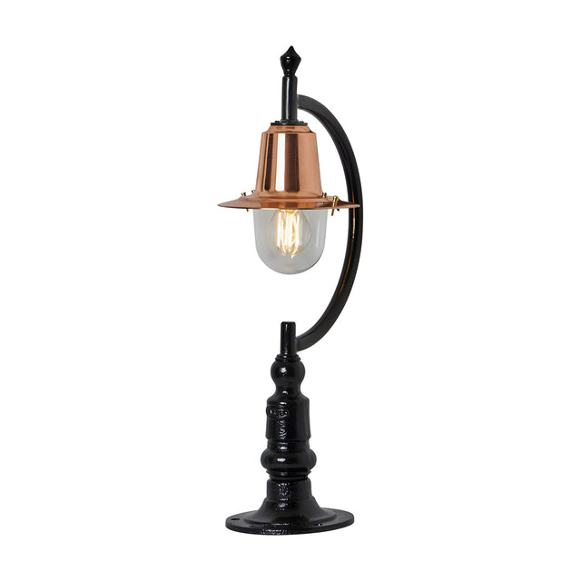Small vintage pillar light for flat piers with a black gooseneck curve, copper teardrop shade, clear glass dome, and traditional cast base, shown on a white background.