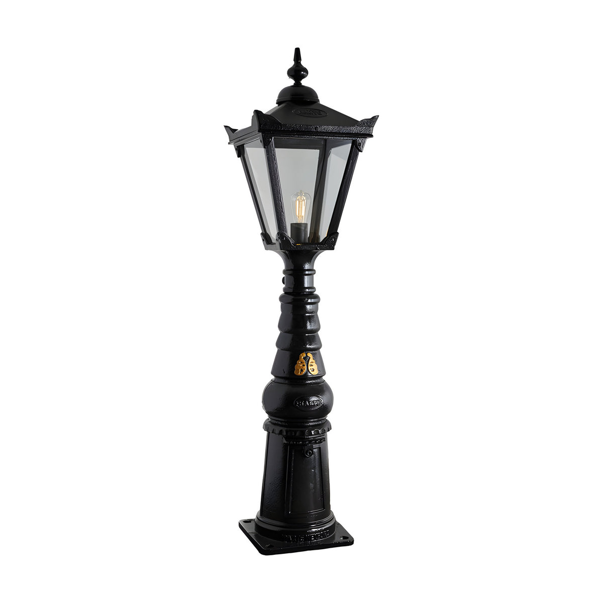 Large Victorian Manor cast iron pedestal post light in black, featuring a hexagonal glass lantern head with pointed finial on a slim ornate column and square base, shown on a plain white background.