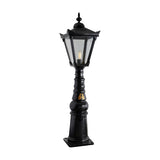Large Victorian Manor cast iron pedestal post light in black, featuring a hexagonal glass lantern head with pointed finial on a slim ornate column and square base, shown on a plain white background.