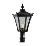 Large Victorian Manor cast iron pedestal post light in black, hexagonal lantern head with clear glass panels and exposed bulb, ornate finial top, shown against a plain white background.