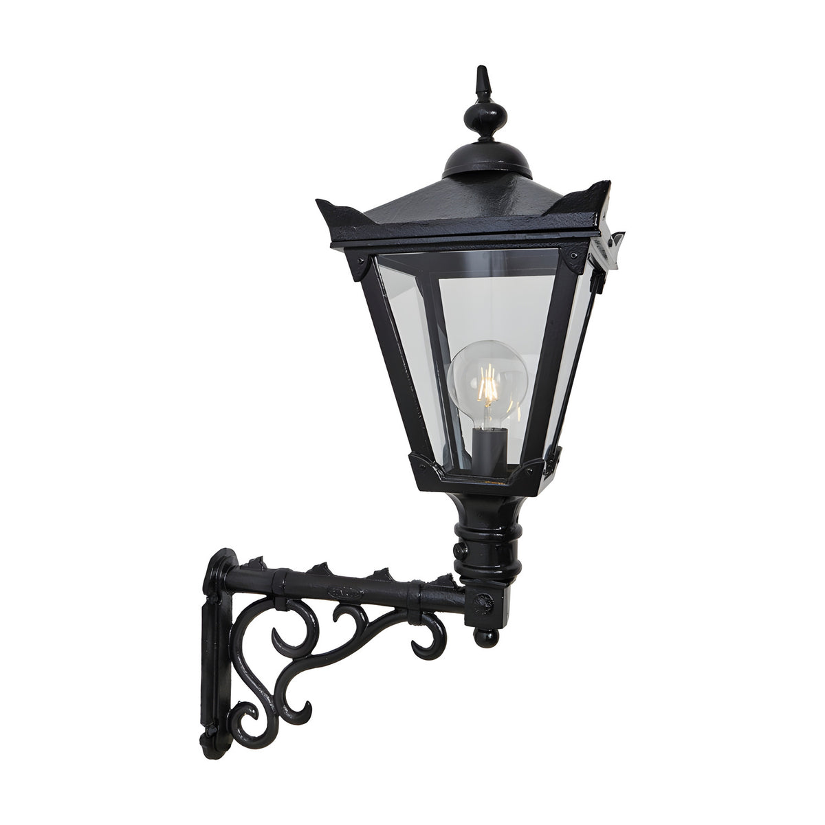 Victorian Manor black outdoor wall lantern with clear glass panels and pointed finial, mounted on an ornate scroll bracket, shown against a plain white background.