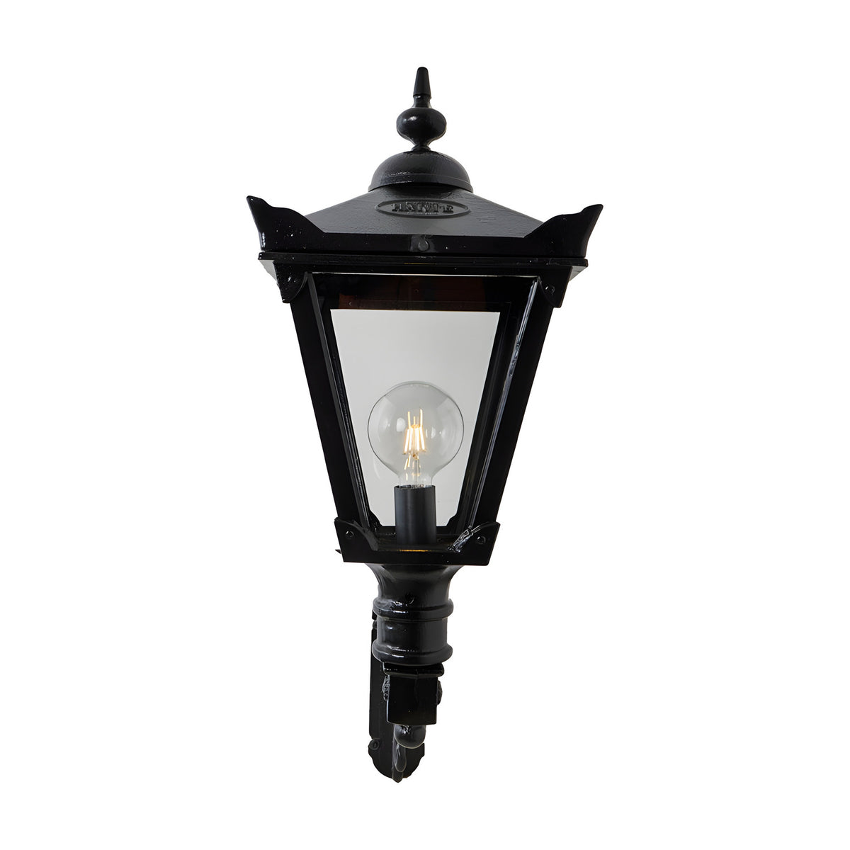 Victorian Manor black wall lantern with clear glass panels and an exposed bulb, mounted on a scroll bracket, shown against a plain white background.