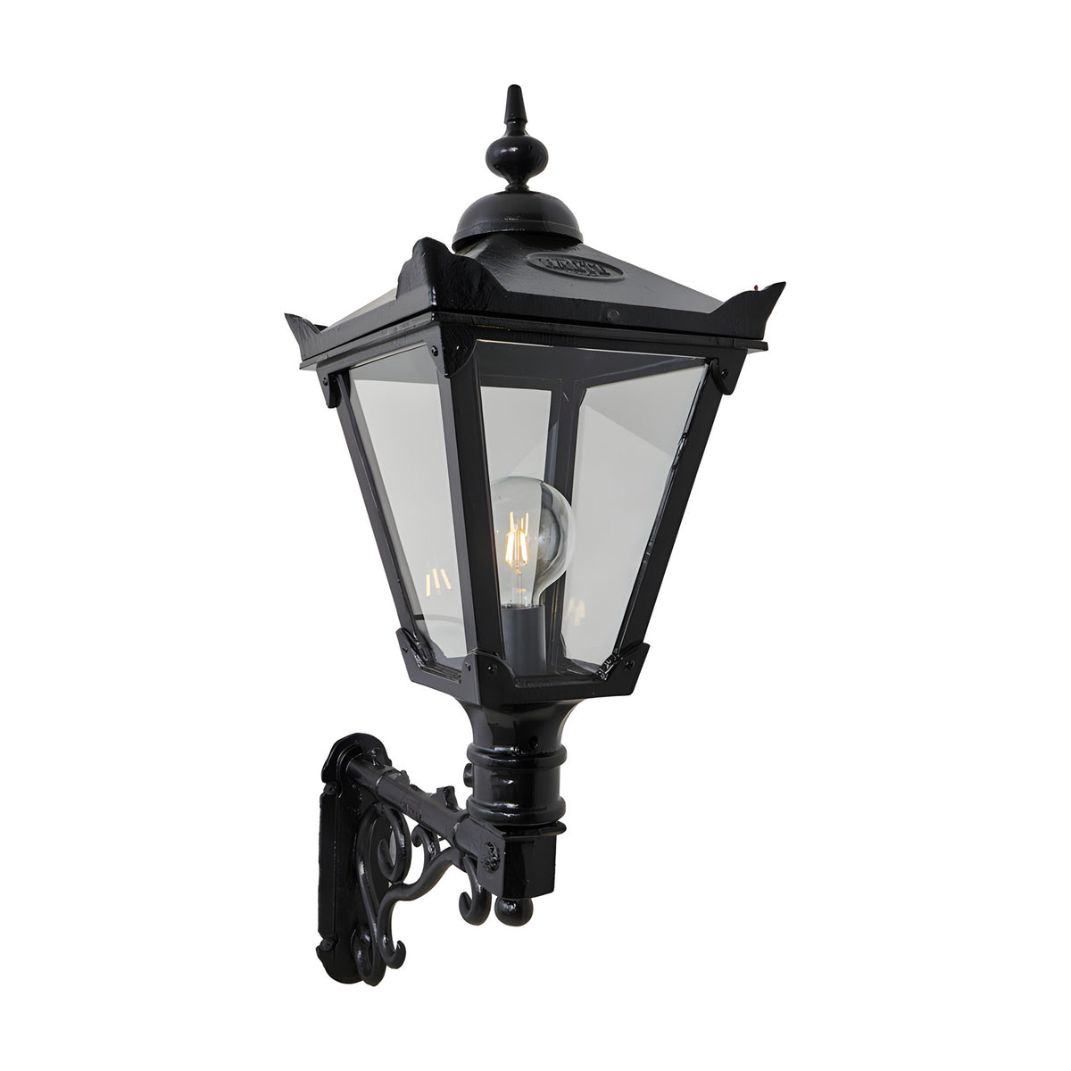 Victorian Manor black wall lantern with clear glass panels and finial top, mounted on a decorative scroll bracket, shown against a plain white background.