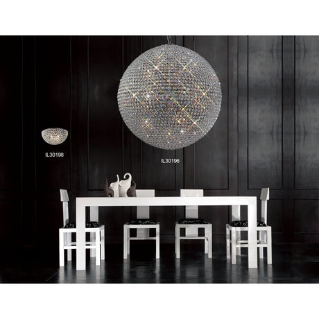 Ava 18 Light G9 Chandelier in polished chrome and clear crystal, shown as a large spherical fixture hanging above a white dining table in a dark-panelled room.