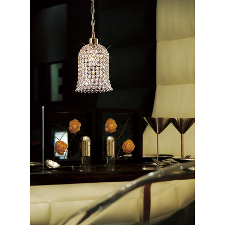 Kudo Lamp Shade 19cm Crystal in French gold, bell-shaped and hung from a chain fitting above a table setting in a dining room.