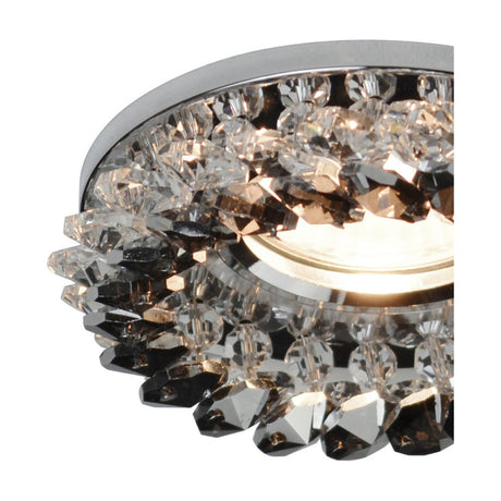 Close-up of the Crystal Round Downlight Rim, 10cm smoked crystal cluster set in a polished chrome frame, lit from behind against a white background.