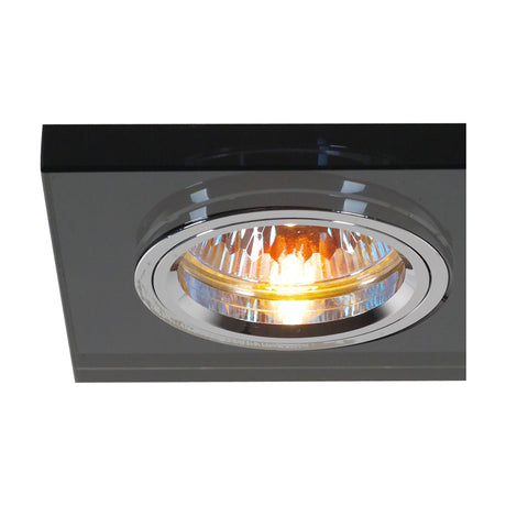 Rectangular downlight rim in black crystal, 144mm cut-out, shown recessed with one chrome-trimmed lamp aperture illuminated, on a white background.