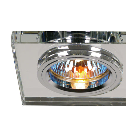 Close-up of the Crystal Rectangle Downlight Rim, clear crystal trim with a chrome bezel surrounding a lit halogen bulb, shown against a plain white background.