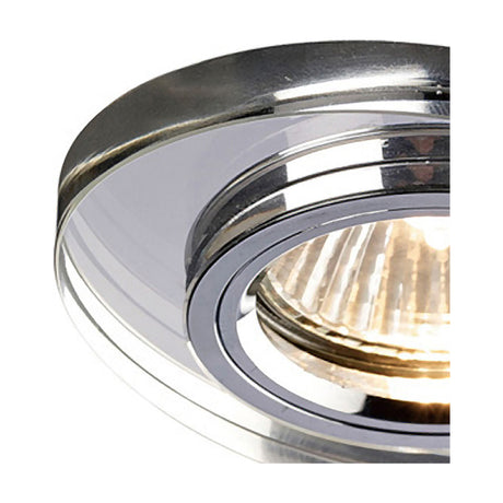 Close-up of a clear crystal downlight rim with 62mm cut-out, oval shape and faceted edge, shown with a lit halogen bulb against a white background.