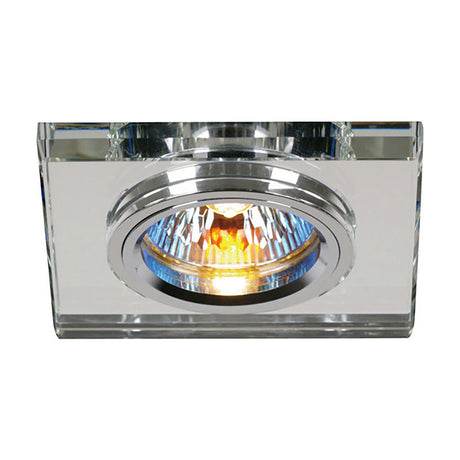 Square clear crystal downlight rim with a chrome inner ring surrounding a lit halogen bulb, shown on a plain white background.