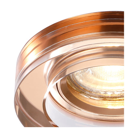 Close-up of a crystal round downlight rim in rose gold with a layered stepped profile, 62mm cut-out, 90mm face, shown lit against a plain white background.