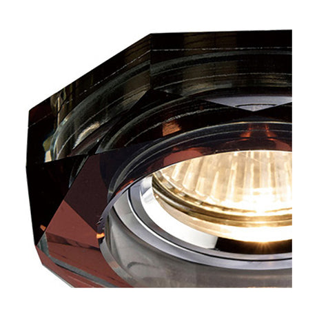 Close-up of a Crystal Downlight Rim in purple, showing its faceted octagonal profile with a 62mm cut-out around an illuminated chrome lampholder.