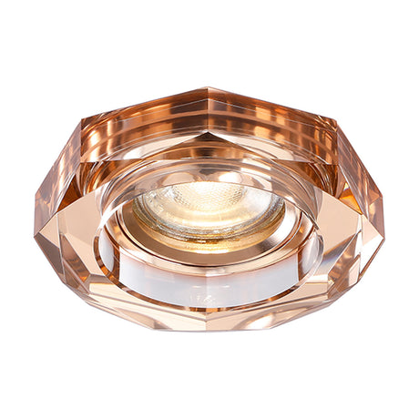 Crystal downlight rim in rose gold with a faceted octagonal outline, 62mm cut-out, shown with lit bulb centre on a plain white background.