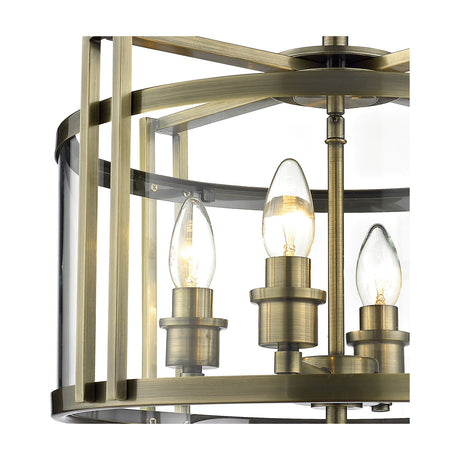 Close-up of the Eaton 4 Light E14 Semi Flush Ceiling Light, showing candle bulbs, antique brass frame, and clear glass shade against a white background.