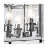 Close-up of the Aston 4 Light Lantern Semi Flush Ceiling Light, showing four lit candle bulbs on polished chrome fittings within a clear glass frame.