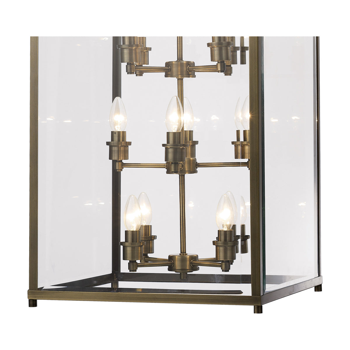 Close-up of the Aston 12 Light E14 Pendant Light in antique brass, showing candle-style bulbs on branching arms within a clear glass rectangular frame.