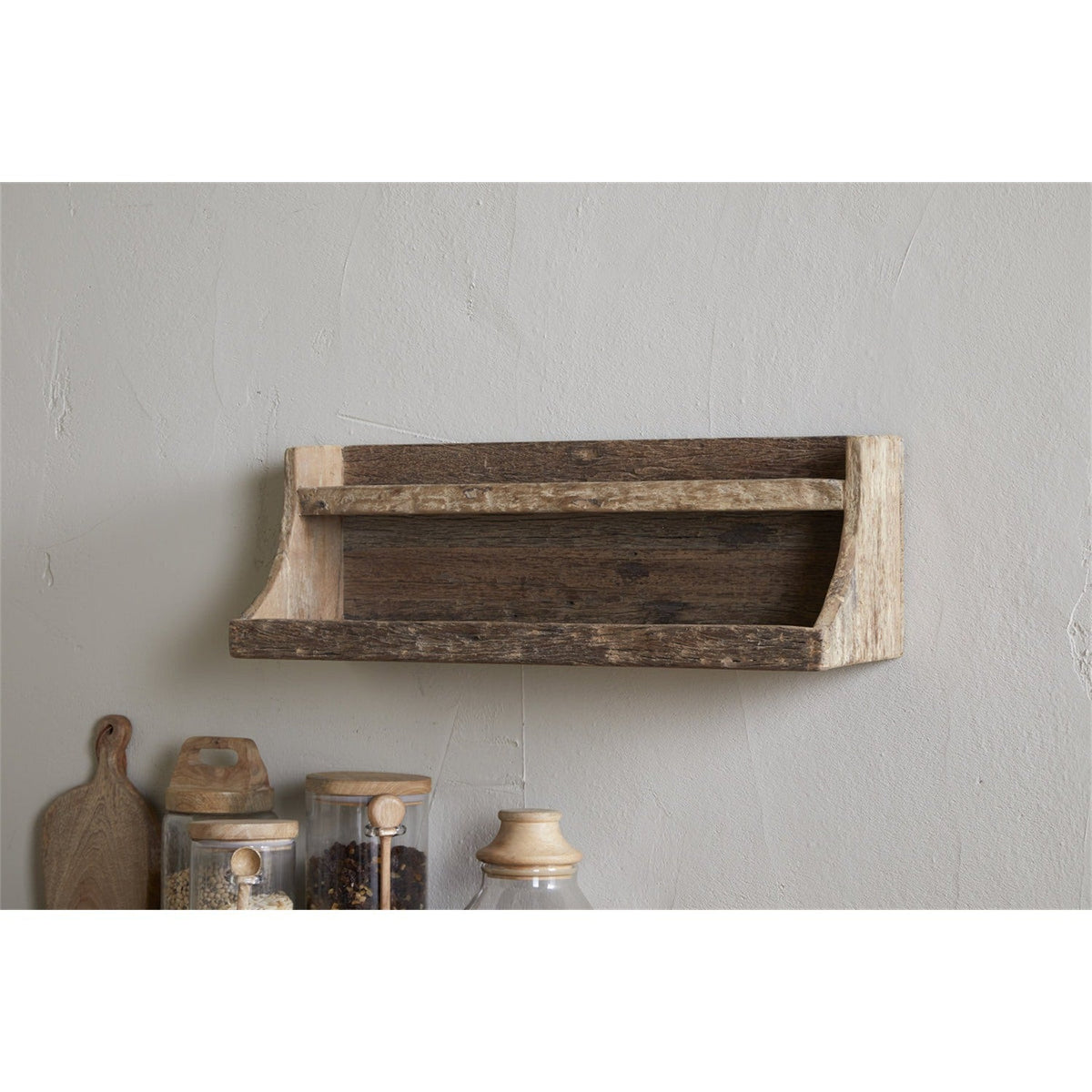 Ibo Reclaimed Wood Wall Shelf in natural tones, mounted on a light grey wall above a kitchen counter with jars and wooden utensils, featuring a two-tier design with curved side brackets.